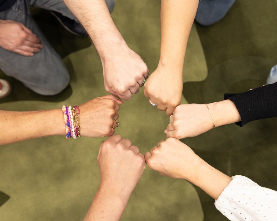 6 handen komen samen in een boks