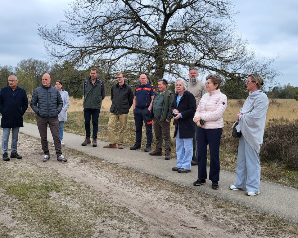 Burgemeester Wilma Delissen en collega's van andere gemeenten en de veiligheidsregio staan in een natuurgebied