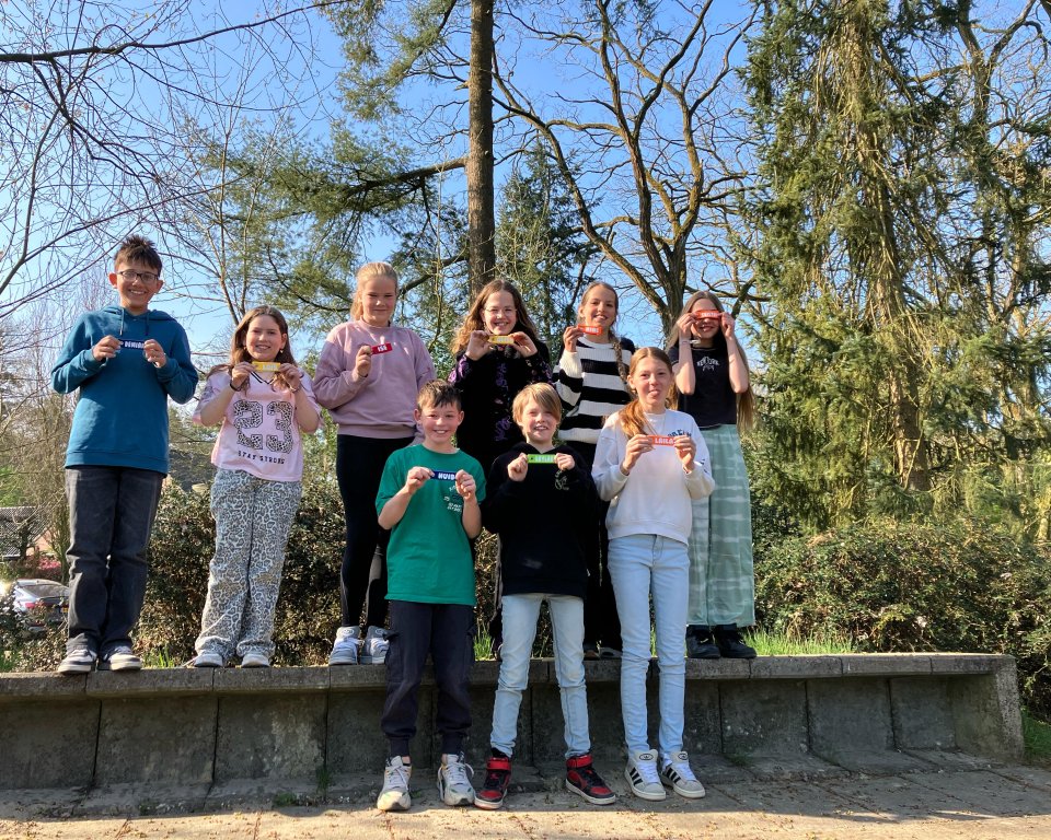 Leerlingen van de basisschool staan met een sleutelhanger in de hand