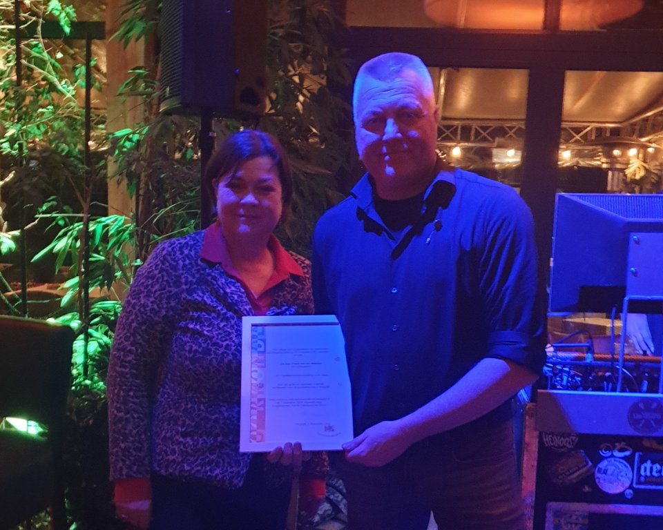 Burgemeester Arinda Callewaert en Frans van der Meijden met de vrijwilligersonderscheiding in zijn handen.