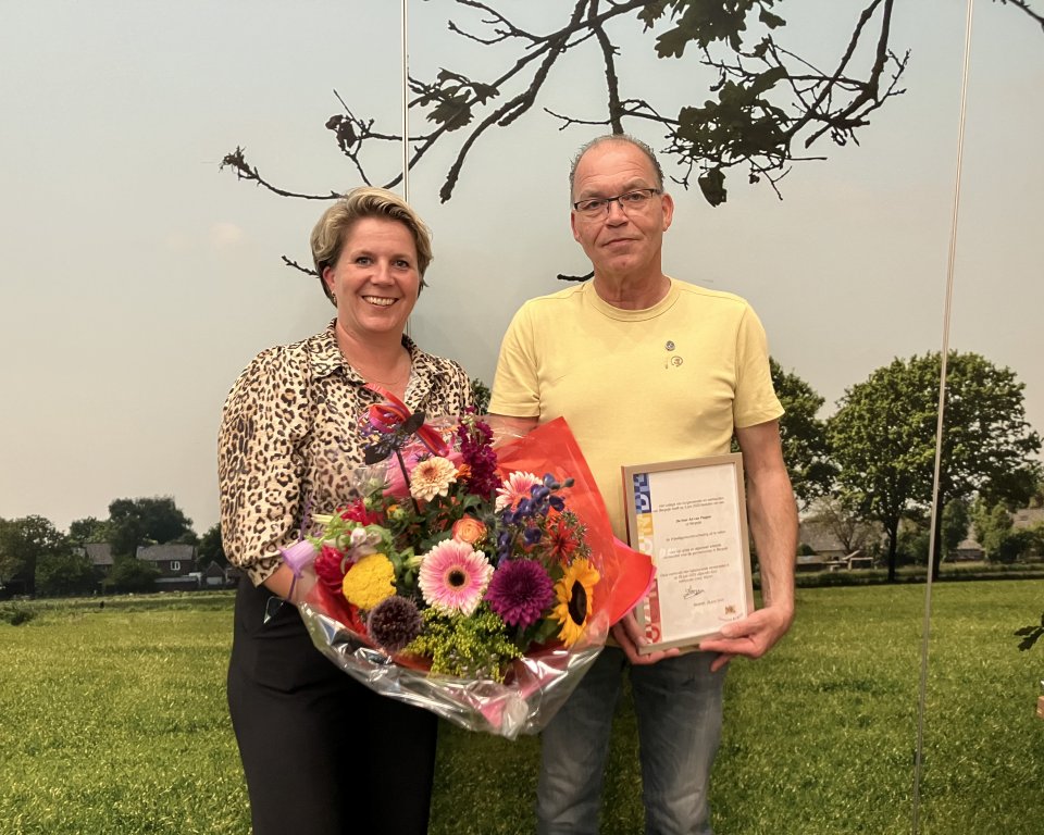 Wethouder Lindy Wijnen en Ad van Poppel met een vrijwilligersonderscheiding in de hand