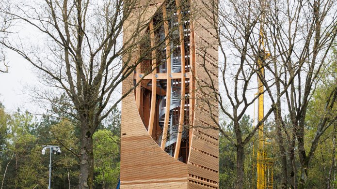 Uitkijktoren met bouwhek eromheen en bouwmaterialen eromheen