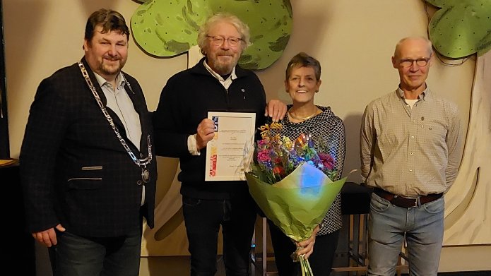 Wethouder Marko van Dalen met 3 vrijwilligers met de onderscheiding en een bos bloemen in de hand