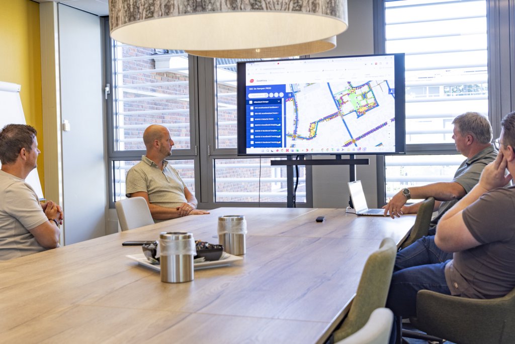 Collega's aan tafel kijken naar een scherm