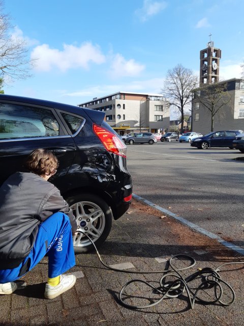 Iemand die een autoband op spanning brengt