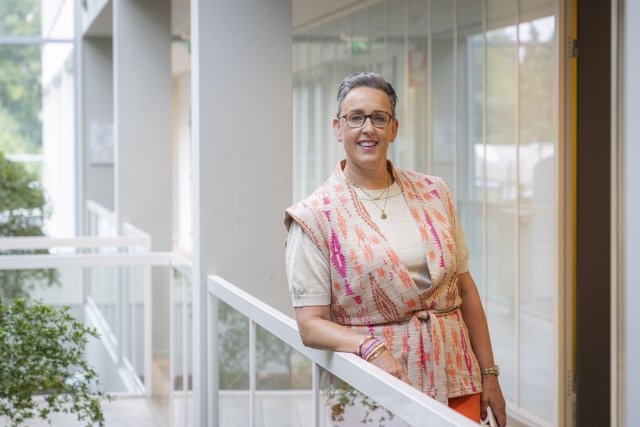 Anouk Versteegden leunt op een ballustrade in het gemeentehuis