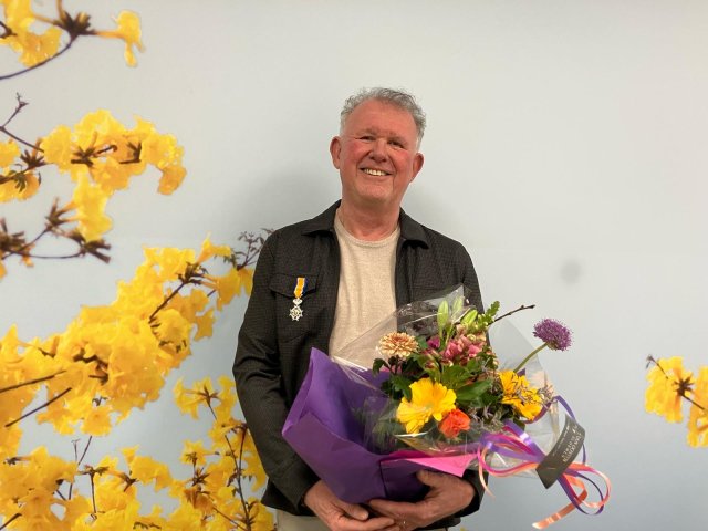 Hans Timmerman met een bos bloemen in zijn hand