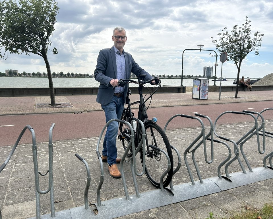 Hans Peter Verroen plaats een fiets in fietsenrek