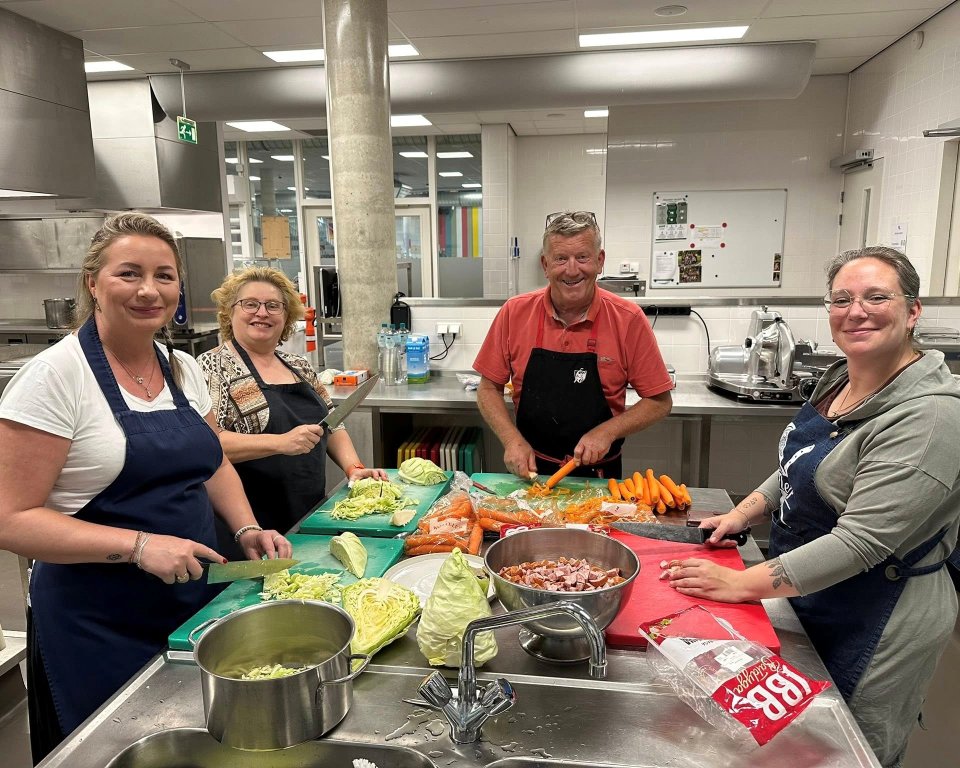 Deelnemers in een keuken die meedoen aan de kookworkshop