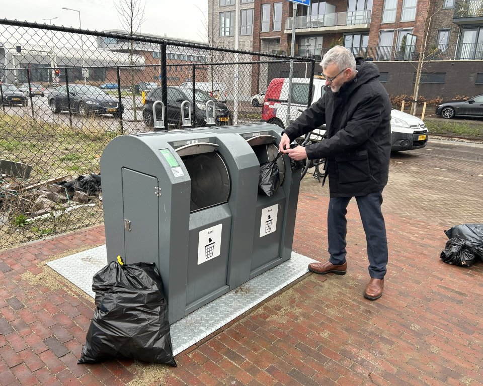 Wethouder Hans Peter Verroen geeft demonstratie voor de restafvalcontainer