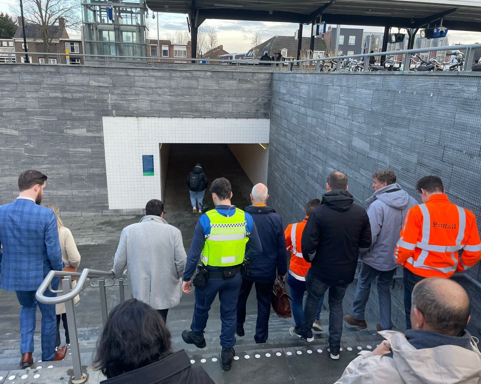 Een groep mensen loopt de trap af naar de voetgangerstunnel op station Bergen op Zoom.