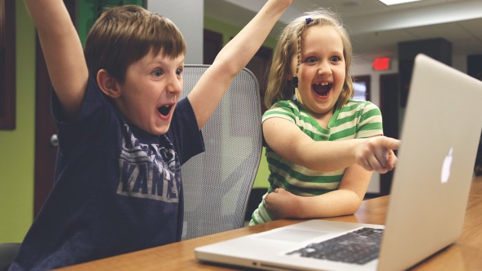 Juichende kinderen achter laptop 