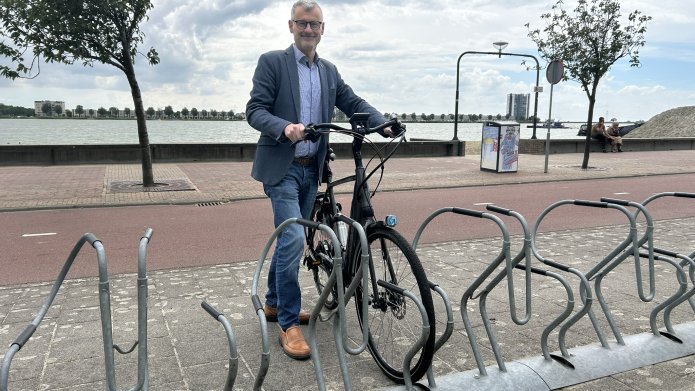 Hans Peter Verroen plaats een fiets in fietsenrek