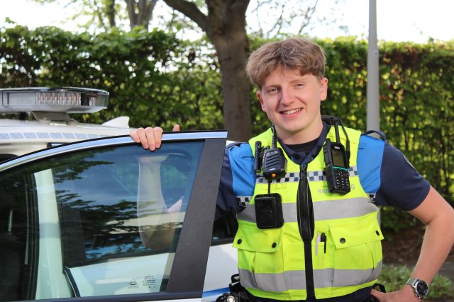 Boa bij één van de auto's, de deur staat open en daar houdt hij zijn hand op.