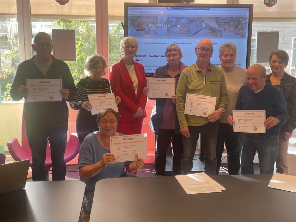 Groepsfoto van de acht deelnemers aan de cursus Digisterker samen met wethouder Hetty van der Hamsvoort
