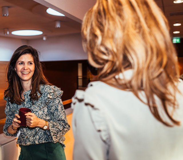 Twee vrouwelijke collega's zijn met elkaar aan het praten