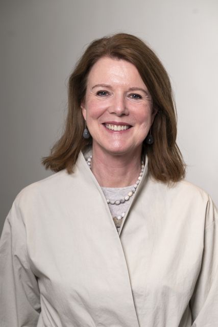 Persoon met licht outfit poseert voor een neutrale achtergrond