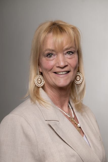 Persoon met licht outfit poseert voor een neutrale achtergrond