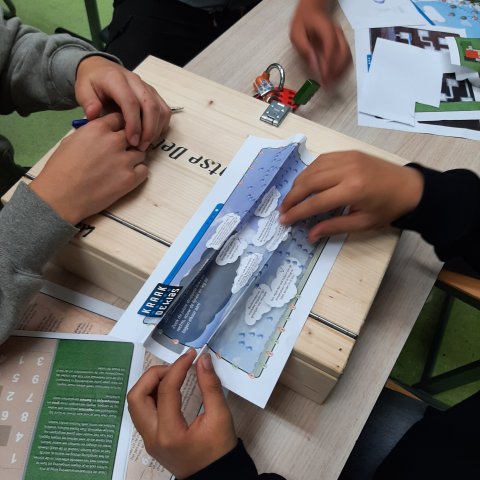 Leerlingen lossen hoosbui puzzel op voor code kraak de klas spel