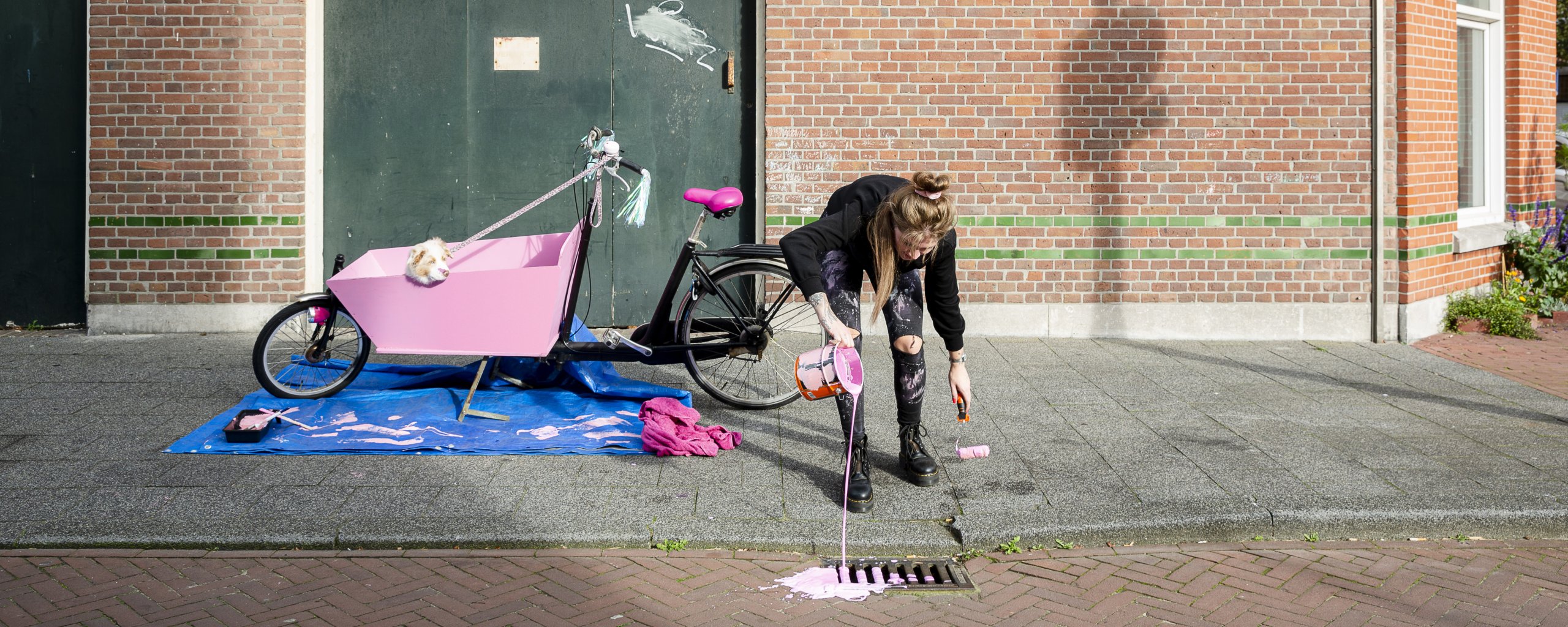 mevrouw gooit verf uit het blik in het putje