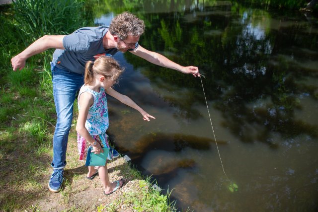 Man en kind meten de waterkwaliteit