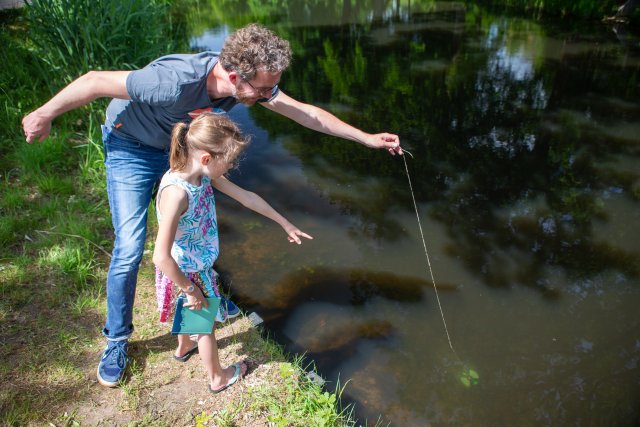 Man en kind meten de waterkwaliteit 