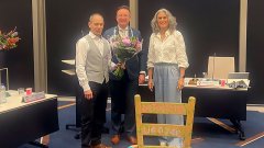 Ed Breuer met een bos bloemen in de hand, burgemeester van Domburg en griffier Veenbergen, na de benoeming