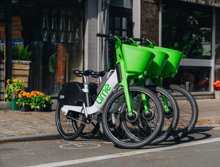 Drie herkenbare wit met groene Limefietsen in een parkeervak
