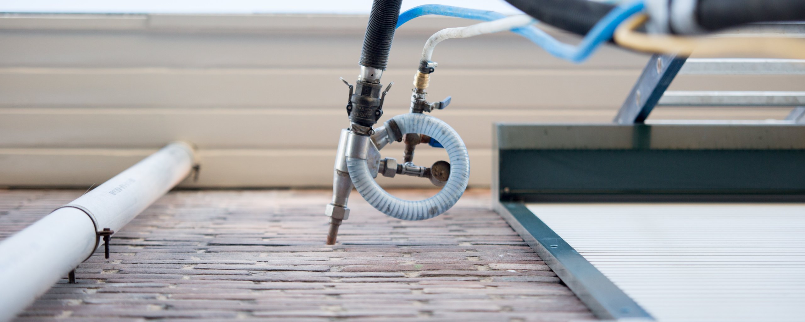 Boorinstallatie die isolatiemateriaal in een bakstenen gevel spuit voor spouwmuurisolatie.