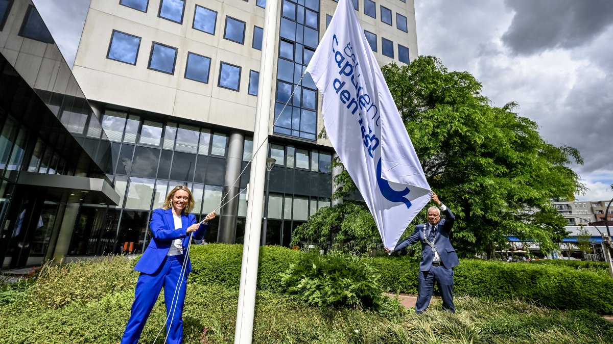 Vernieuwd Capels logo, gemeentesecretaris en burgemeester hijsen symbolisch de vlag