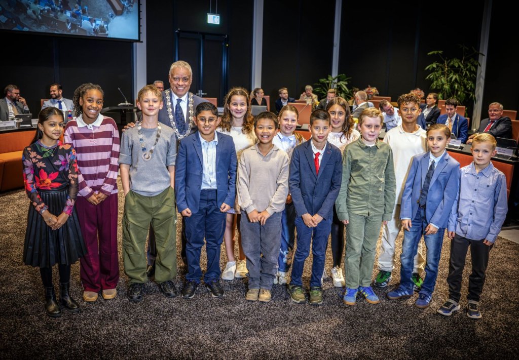 Burgemeester Joost Manusama met het Kindercollege 2026-2027, dat bestaat uit Noël Terlouw, Lizzy Arnoldus, Jonah van Eijk, Lieneke Schumacher, Ilay de Burgo, Joah Verweij, Nika Shapouri, Ajooni Singh, Olivier de Vries Potuijt, Aemahni-Jade Mercelita, Paritosh Baidjnath, Zhi Xiang Sit en Mateo Verweij.