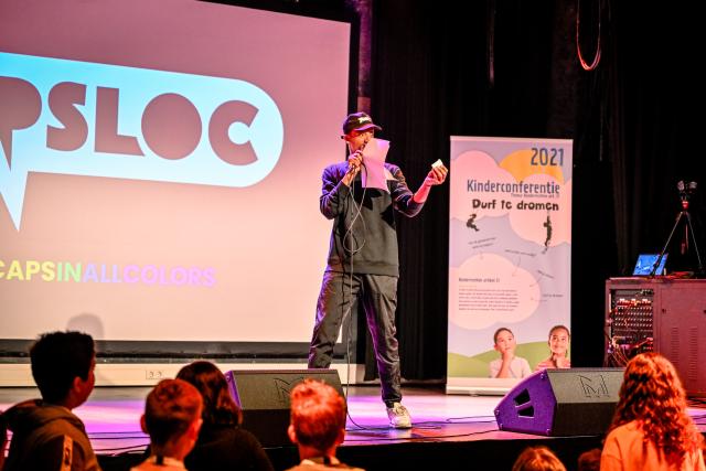 Rapper op podium van CAPSLOC tijden kinderconferentie 2021