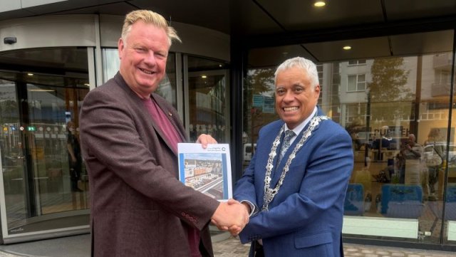 Wethouder Rik van Woudenberg overhandigt de Begroting 2026 aan burgemeester Joost Manusama (Foto: Gemeente Capelle aan den IJssel)