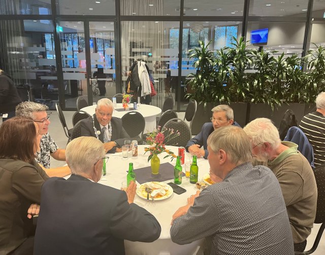 Burgemeester aan tafel met een aantal veteranen