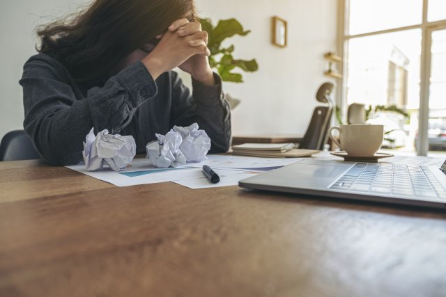 Vrouw zit bezorgd achter een aantal rekeningen