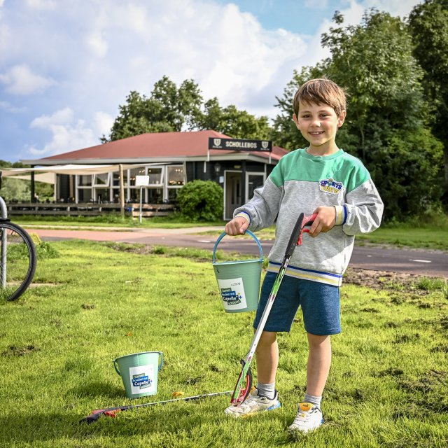 Een kind met een emmertje en een afvalgrijper voor het Pannenkoekenhuis