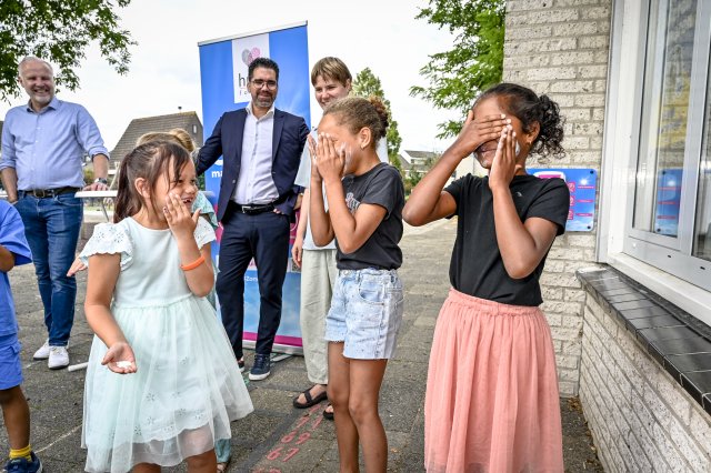 Kinderen smeren zichzelf in met zonnebrandcrème.