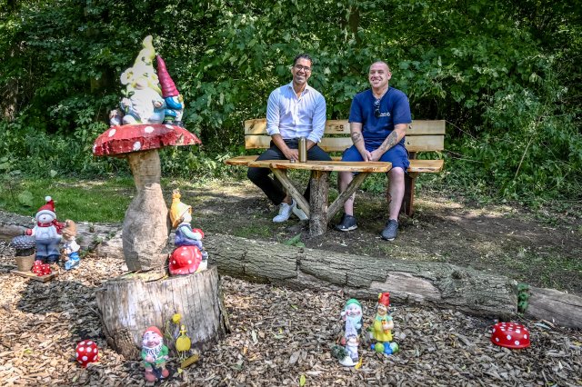 Wethouder Marc Wilson en collega Danny op een zelfgemaakt bankje bij het Kabouterbos