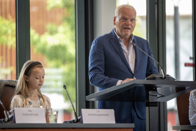 Wethouder Eric Faassen tijdens de eindpresentatie van het Kindercollege.