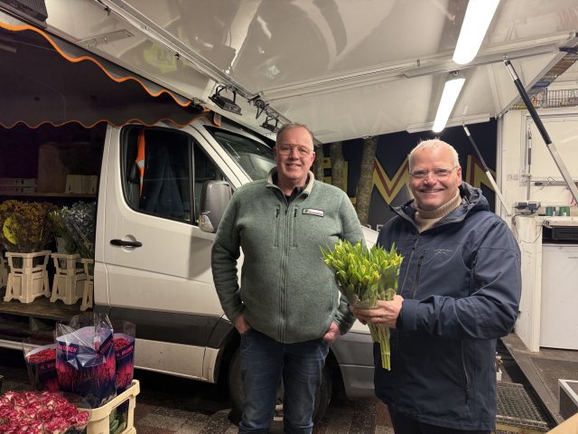 Wethouder Eric Faassen bij de bloemenkraam op de weekmarkt