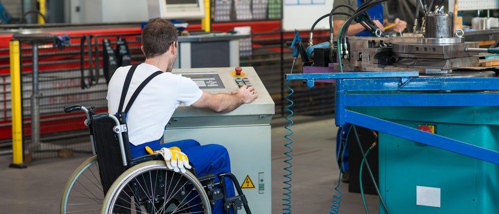 jongen in een rolstoel aan het werk in een magazijn