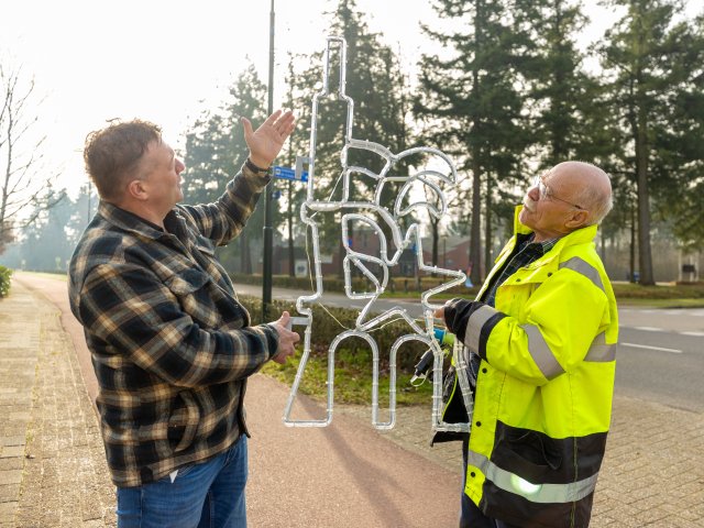 Twee mensen met een lichtornament in hun handen
