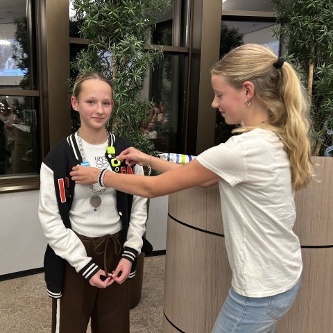 Oud-kinderburgemeester Lela Dijsselhof hangt kinderburgemeester Milou Groen de ambtsketen om.