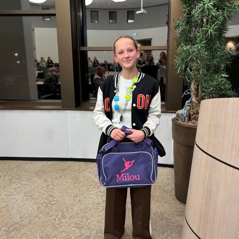 Kinderburgemeester Milou Groen met haar cadeau: een tas met haar naam erop.