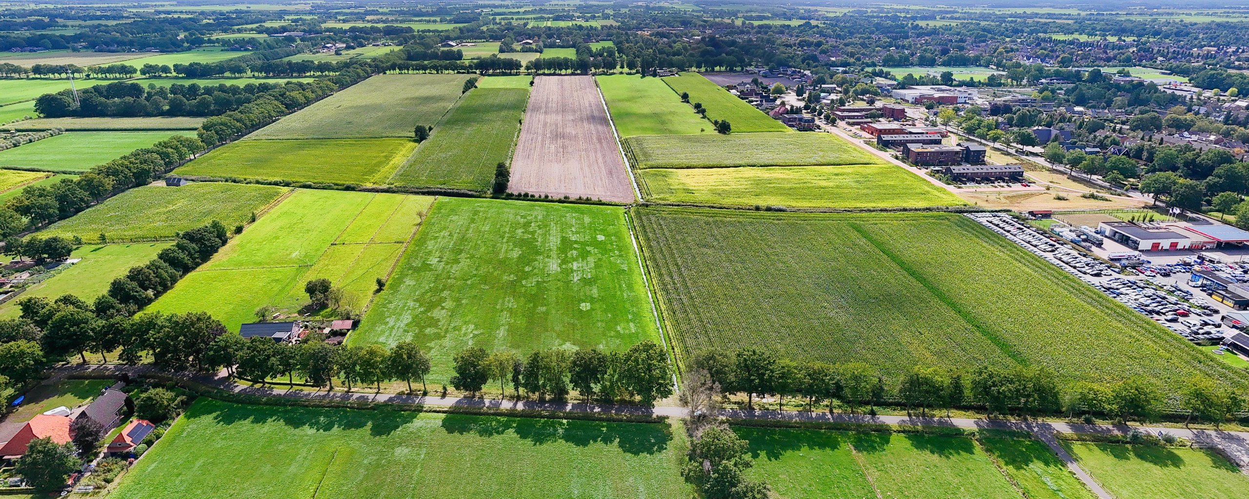 Luchtfoto met weilanden op de plek van de nieuwe wijk Palthelanden.