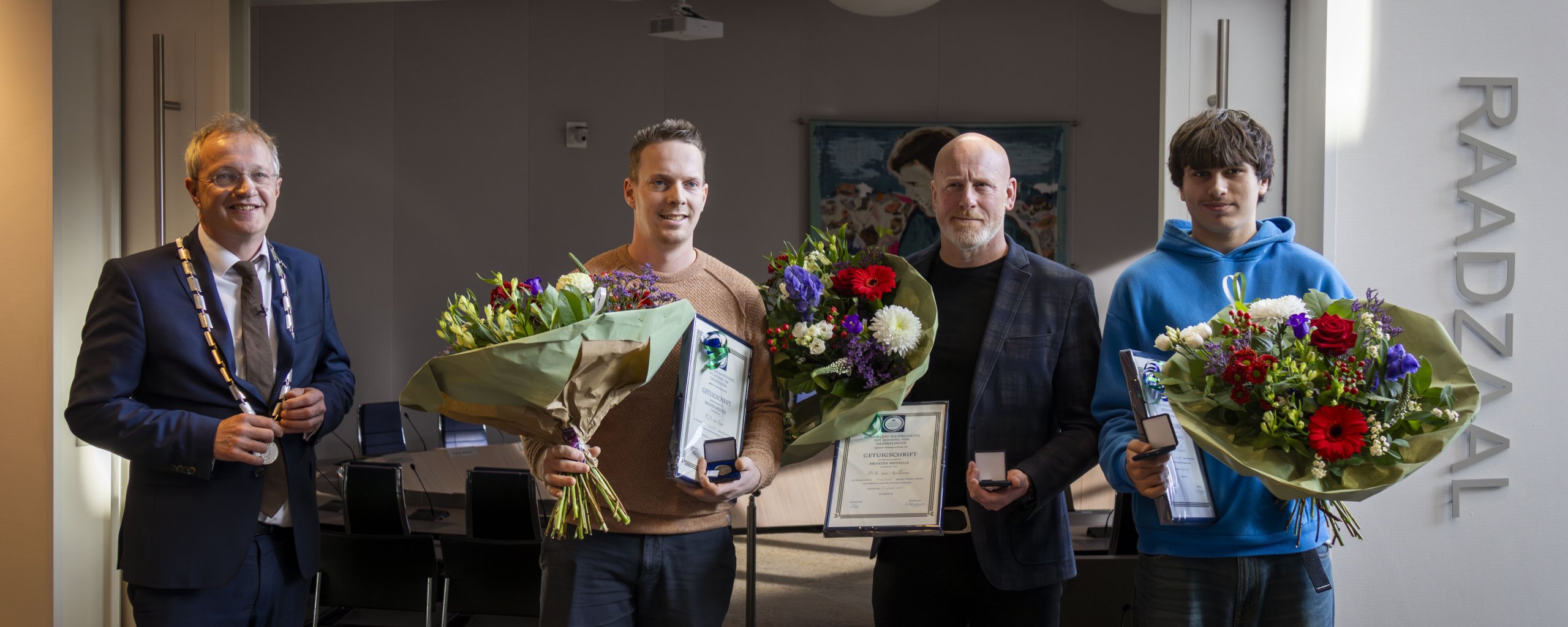 Foto van de uitreiking met burgemeester Michael Sijbom en de redders.