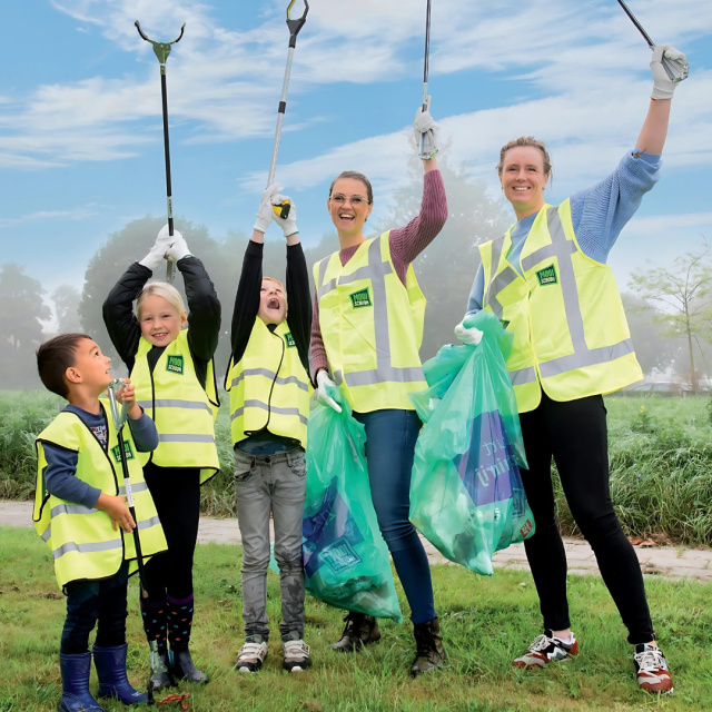Op de afbeelding staan 5 mensen die met knijpers en vuilniszakken zwerfafval gaan opruimen.