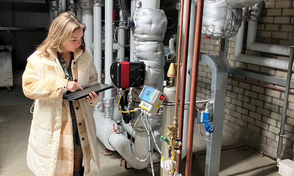 Foto van een medewerker gemeente Deurne die een verwarmingsinstallatie controleert, afdeling Beheer en Onderhoud