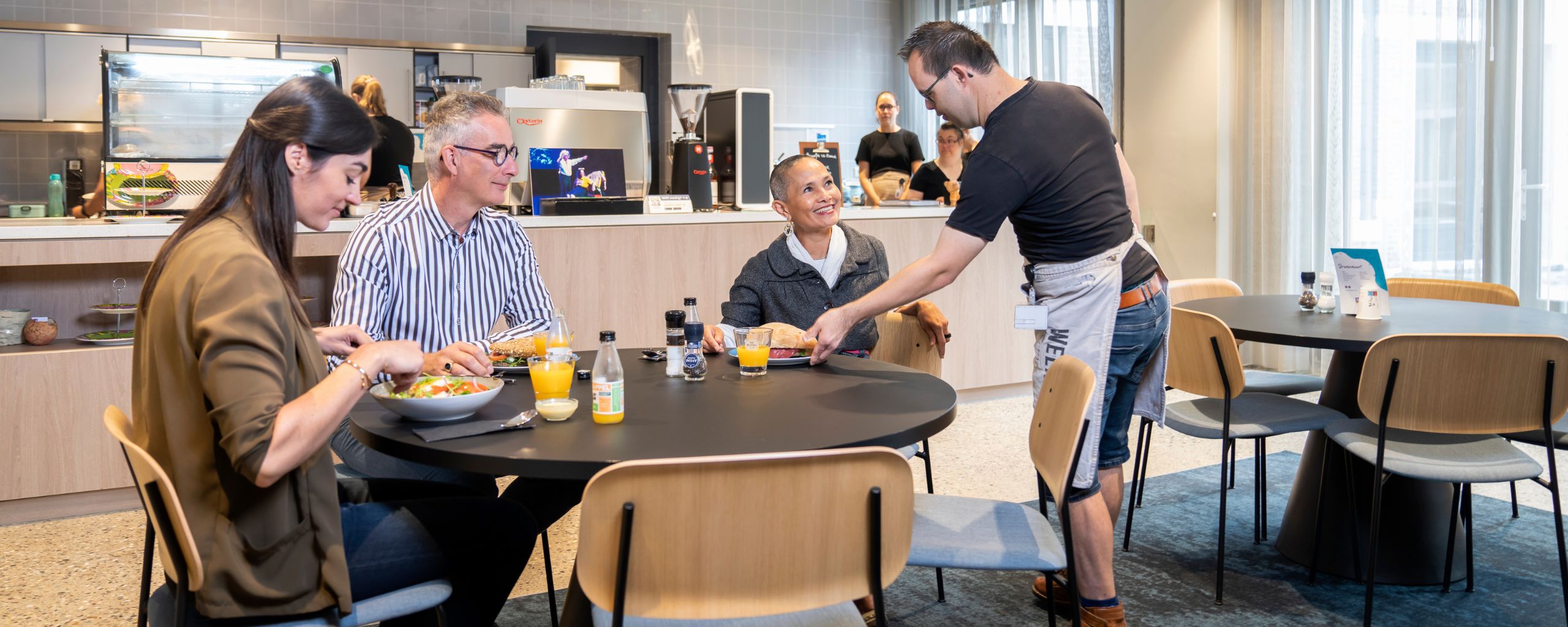 Drie personen in lunchrestaurant krijgen lunch geserveerd