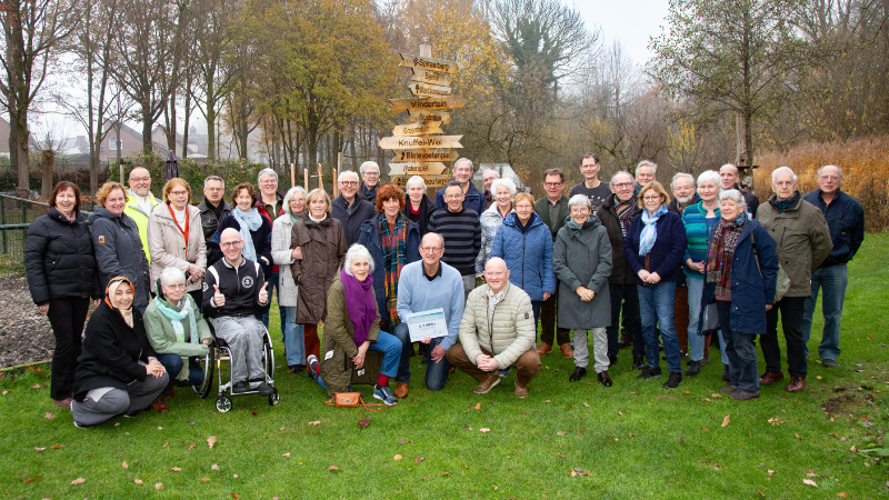 Groepsfoto van de vrijwilligers van de Ossenbeemd samen met wethouder Riny van Rinsum